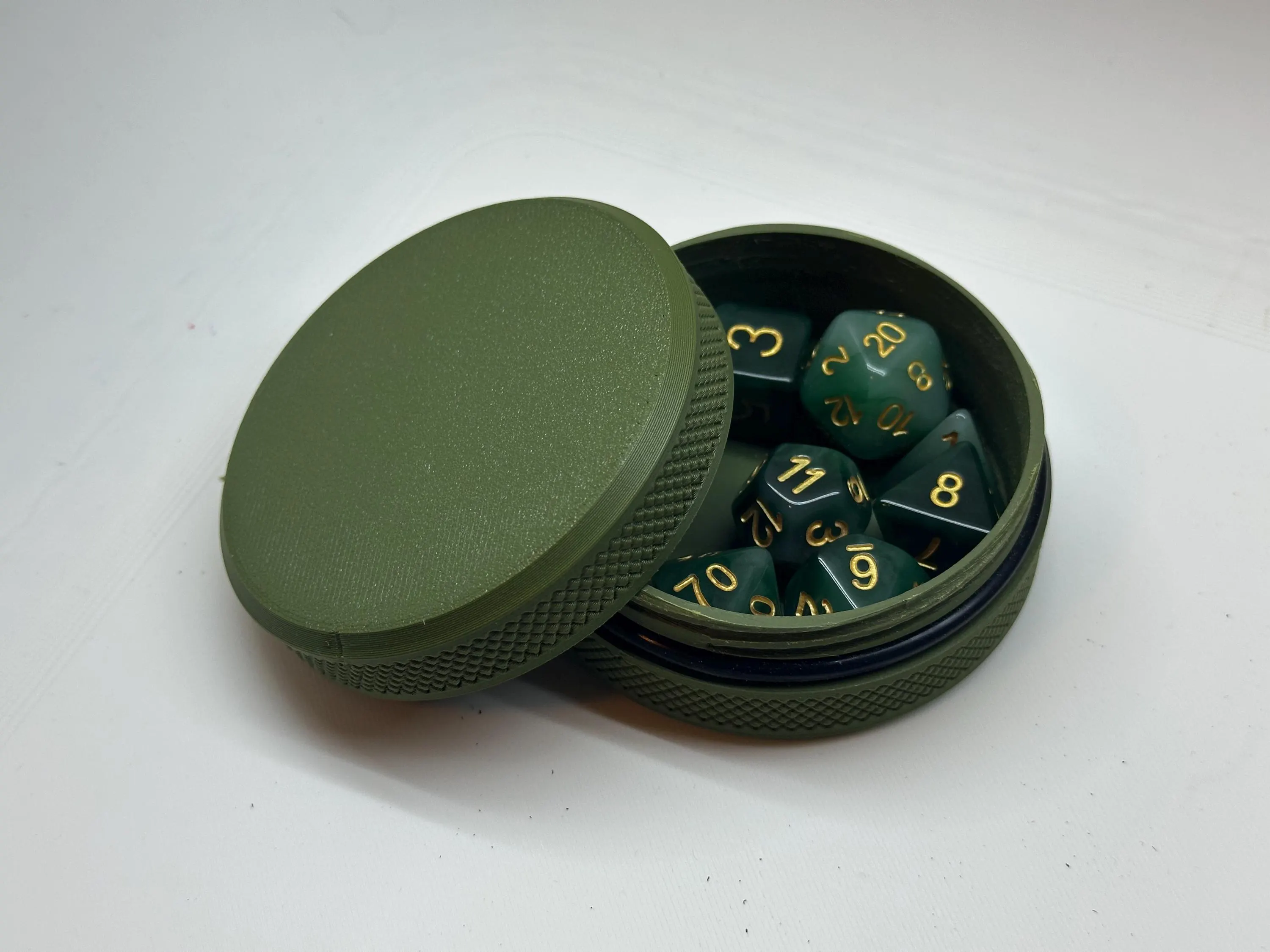 Open green dice tin with a full set of green polyhedral dice inside