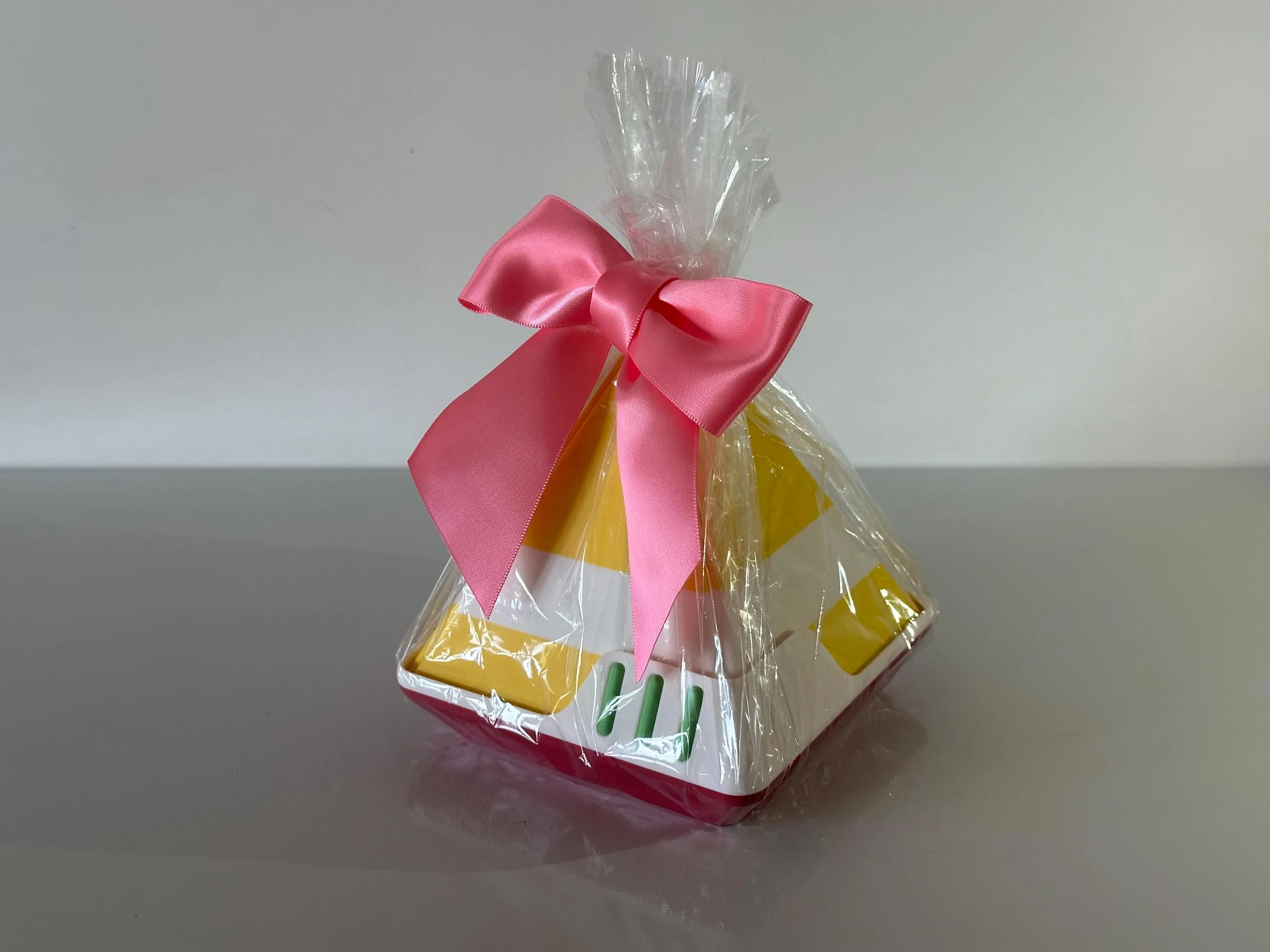 The 4.5 inch gift box wrapped in cellophane and finished with a pink ribbon